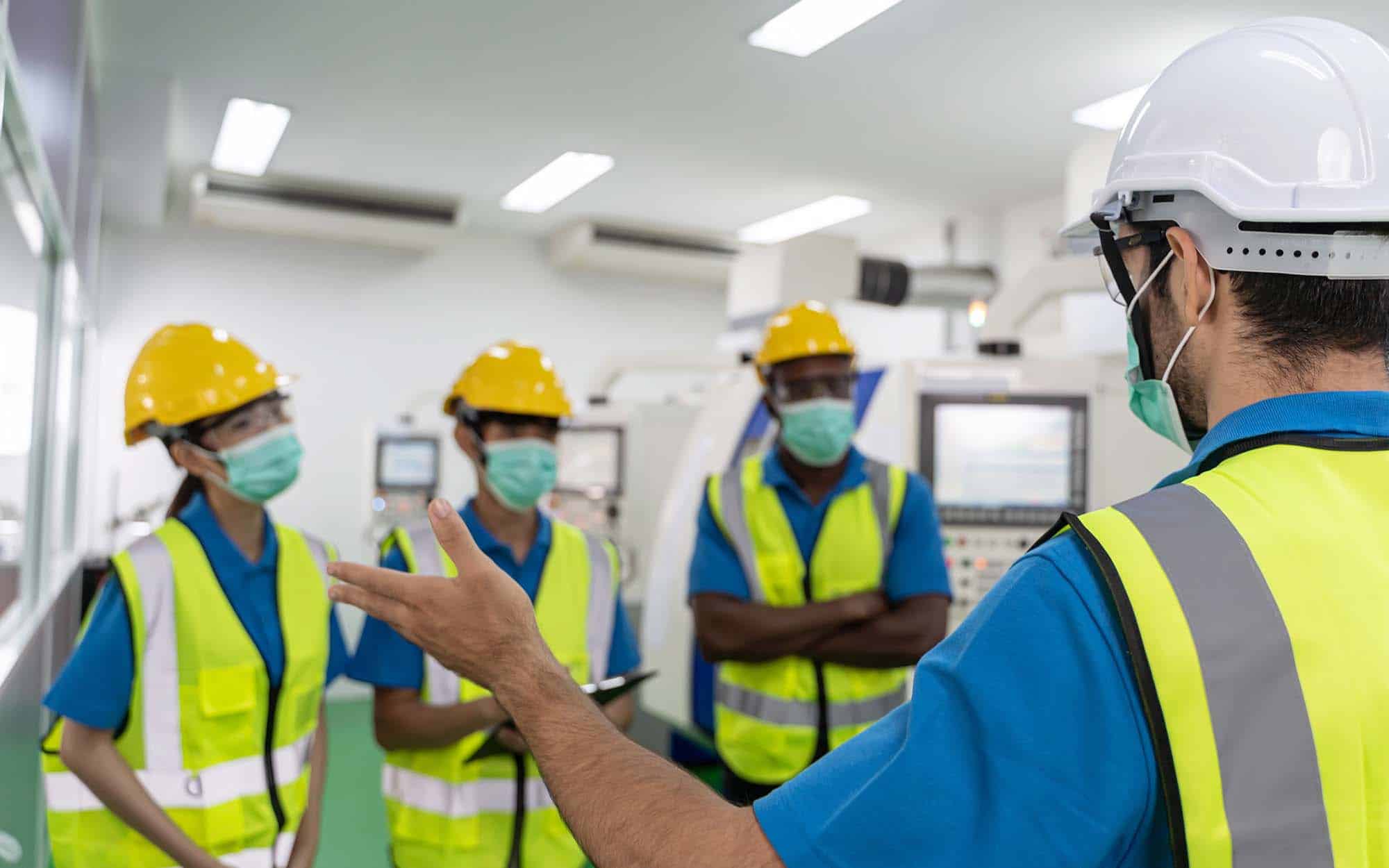 Workers in safety vests and hard hats during a workplace safety training session