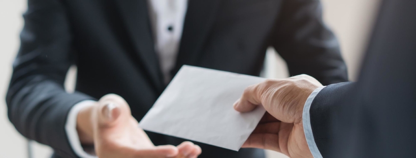 Image of an employer handing a check to their employee.