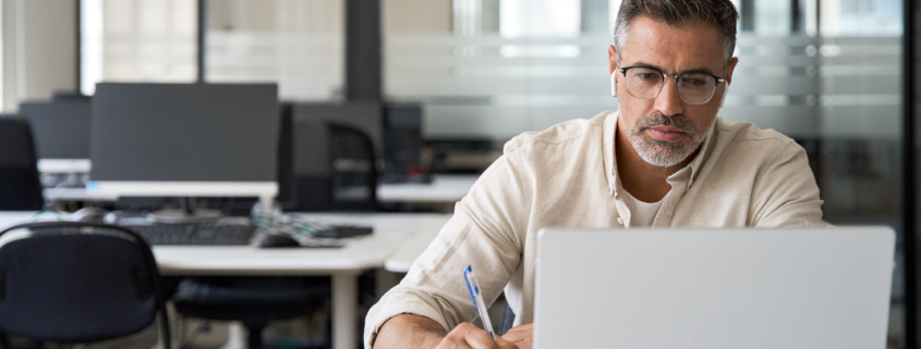 Middle-age Hispanic man using laptop computer for business