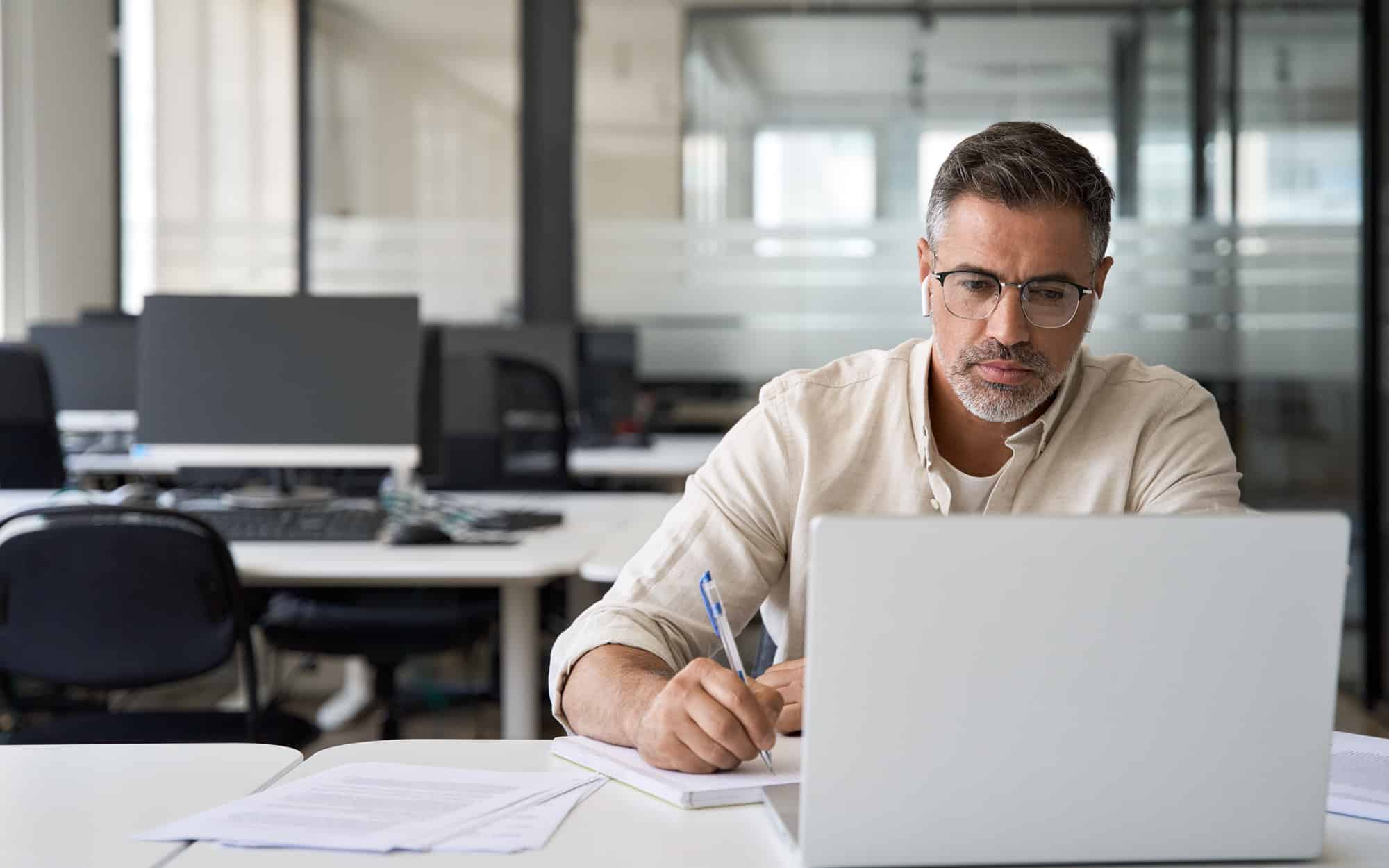 Middle-age Hispanic man using laptop computer for business