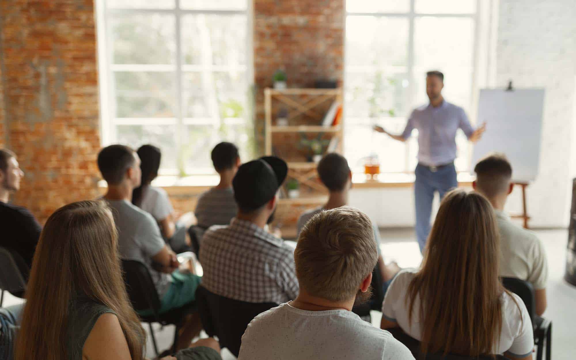 HR Credit EasyPass A presenter leading a session for a group of business professionals, representing HR Credit EasyPass recertification courses
