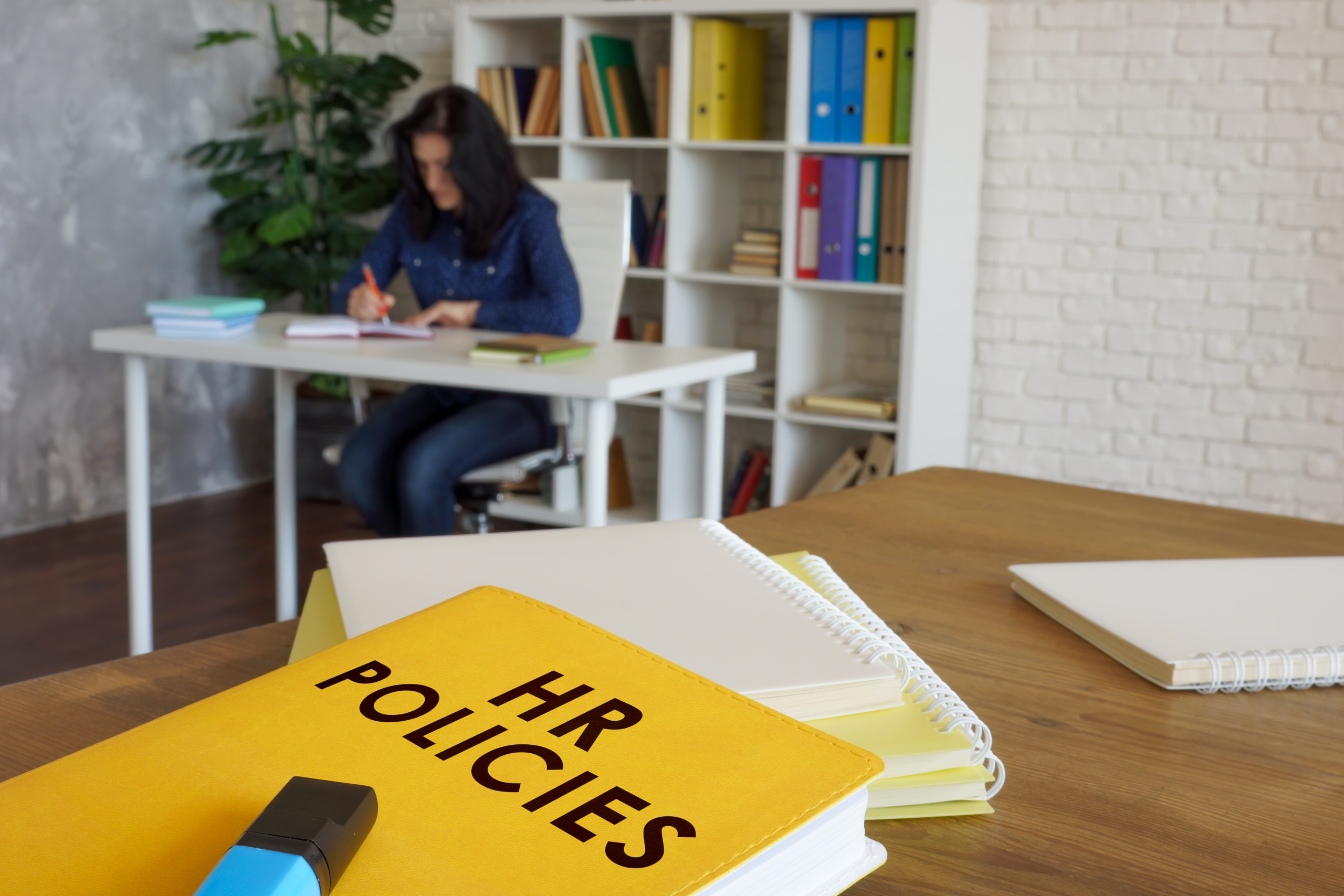 Binder labeled HR Policies on a desk, representing employment law and compliance training