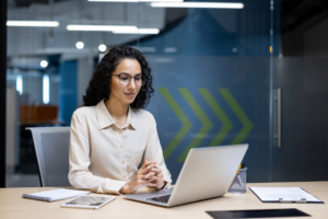 HR professional using AAIM’s online HR libraries on a laptop, reviewing compliance tools and templates in a modern office setting